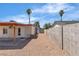 A large, sunny backyard featuring a covered patio, gravel landscaping, and mature palm trees at 1158 E Hacienda Ave, Las Vegas, NV 89119