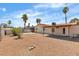 A large backyard featuring a covered patio, gravel landscaping, and mature palm trees at 1158 E Hacienda Ave, Las Vegas, NV 89119