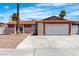 Single-story home featuring a two-car garage, desert landscaping, and a red and beige exterior at 1158 E Hacienda Ave, Las Vegas, NV 89119