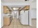 Efficient kitchen featuring wood cabinets and modern white appliances with tiled flooring at 1158 E Hacienda Ave, Las Vegas, NV 89119