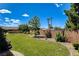 Green backyard features a grass lawn, mature trees, desert landscaping, and a brick wall at 1182 Thomas Bay Cir, Logandale, NV 89021