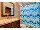 Bathroom features a vanity, toilet, and tub with colorful curtain at 1182 Thomas Bay Cir, Logandale, NV 89021
