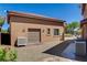 Rear view of a detached two-car garage showcasing desert landscaping, and exterior lighting at 1182 Thomas Bay Cir, Logandale, NV 89021