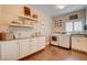 Well-lit laundry room features ample cabinetry, countertop space, washer, dryer, and wood-look floors at 1182 Thomas Bay Cir, Logandale, NV 89021