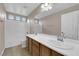 Bright bathroom with double sinks, white countertops, large mirror, and tub-shower combo at 125 Sharp Edge Ave, North Las Vegas, NV 89031