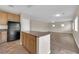 View of kitchen area with countertop bar and stainless steel refrigerator leading to the living room at 125 Sharp Edge Ave, North Las Vegas, NV 89031