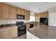 A kitchen featuring granite countertops, wooden cabinets, and black appliances at 125 Sharp Edge Ave, North Las Vegas, NV 89031