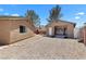 Spacious backyard featuring a detached garage, brick BBQ, and gravel landscaping at 1520 Della Ct, Boulder City, NV 89005