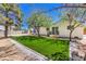 This backyard boasts a small grassy area, patio decks, mature trees, and a secure perimeter fence at 1731 Sherwin Ln, Las Vegas, NV 89156
