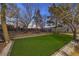 Landscaped backyard featuring artificial turf, mature trees, and decorative rock accents at 1731 Sherwin Ln, Las Vegas, NV 89156