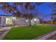 Backyard showcasing an artificial turf lawn with house and patio visible through the trees at 1731 Sherwin Ln, Las Vegas, NV 89156