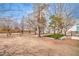 Spacious backyard with artificial turf, mature trees, and partial fencing on a sunny day at 1731 Sherwin Ln, Las Vegas, NV 89156