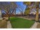 Lush artificial turf in a spacious backyard featuring mature trees and decorative rock landscaping at 1731 Sherwin Ln, Las Vegas, NV 89156