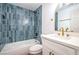 Charming bathroom boasts blue tiling, modern vanity, and shower-tub combination at 1731 Sherwin Ln, Las Vegas, NV 89156