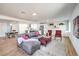 Open-concept living room with gray couch, red chairs, light wood floors, and access to the kitchen at 1731 Sherwin Ln, Las Vegas, NV 89156