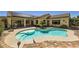 Beautiful backyard featuring a sparkling pool, covered patio, and mature landscaping at 2151 Bannerwood St, Henderson, NV 89044