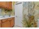 Bright laundry room features a sink and ample wooden cabinets, artistic accent wall, and access door at 2151 Bannerwood St, Henderson, NV 89044