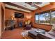 Relaxing living room featuring hardwood floors, a fireplace, exposed beams, and a view of the backyard pool at 2151 Bannerwood St, Henderson, NV 89044