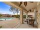 Comfortable covered patio seating area with fan and view of the lush backyard landscaping and pool at 2151 Bannerwood St, Henderson, NV 89044