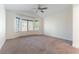 A spacious bedroom featuring plush carpeting, a ceiling fan, and a large window for ample natural light at 2185 High Mesa Dr, Henderson, NV 89012