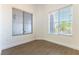 Clean and spacious room featuring modern flooring, white paint, baseboards, and windows with views of greenery at 2185 High Mesa Dr, Henderson, NV 89012