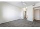 Bright bedroom features neutral carpet, light fixture, and a view to the bathroom at 2201 Ramsgate Dr # 128, Henderson, NV 89074