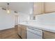 Bright kitchen with white appliances, wood cabinets and partial view to the living room at 2201 Ramsgate Dr # 128, Henderson, NV 89074