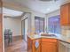 Open-concept kitchen view with wood cabinets, granite counters, and breakfast bar near dining area at 2462 Pickwick Dr, Henderson, NV 89014