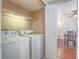 Bright laundry room area featuring a full size washer and dryer next to an indoor living space at 2462 Pickwick Dr, Henderson, NV 89014