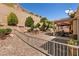 Tiered backyard with lush greenery, a shaded patio, and decorative rock landscaping at 2521 Roseworthy Dr, Las Vegas, NV 89134