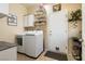 Efficient laundry room with washer, dryer, storage cabinets, and easy access to the outside at 2521 Roseworthy Dr, Las Vegas, NV 89134