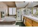 Bright bathroom features a glass shower, a soaking tub, and and sinks at 2543 Farmington Ave, Las Vegas, NV 89120