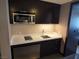 Modern kitchenette equipped with stainless steel appliances, white countertops, and dark wood cabinets at 2600 W Harmon Ave # 20034, Las Vegas, NV 89158