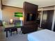 Open-concept living space with a large TV, desk area, and comfortable seating near the bedroom at 2600 W Harmon Ave # 20034, Las Vegas, NV 89158