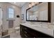Bright bathroom featuring dark vanity, white countertop and large mirror over the sink at 2902 Ventana Ridge Ave, Henderson, NV 89044