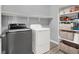 Well-equipped laundry room featuring a washer, dryer, and built-in shelving for ample storage at 3002 Coveri Ct, Las Vegas, NV 89141