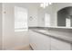 Bright bathroom vanity with a gray countertop, white cabinets, and a large mirror at 3041 Gary Cooper St # 103, Las Vegas, NV 89122