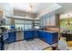 Well-lit kitchen featuring blue cabinetry, modern appliances and a window view at 3061 Brockington Dr, Las Vegas, NV 89120