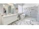 Bright bathroom featuring double sinks, a soaking tub, a walk-in shower, and marble flooring at 3064 Azure Bay St, Las Vegas, NV 89117