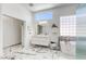 Bright bathroom featuring double sinks, a soaking tub, a walk-in shower, and marble flooring at 3064 Azure Bay St, Las Vegas, NV 89117