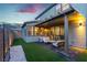 A backyard features a covered patio with an outdoor seating area on a tranquil evening at 3206 Fountaintree Ave, Henderson, NV 89044