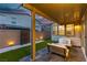 A backyard features a covered patio with an outdoor seating area at dusk at 3206 Fountaintree Ave, Henderson, NV 89044
