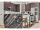 Close-up of a kitchen island with marble countertops and stylish bar stools at 3206 Fountaintree Ave, Henderson, NV 89044