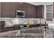 Modern kitchen featuring custom cabinets, granite counters, stainless steel appliances, and marble backsplash at 3206 Fountaintree Ave, Henderson, NV 89044