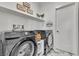 Clean laundry room with modern appliances, decorative signage, and marble style tile at 3206 Fountaintree Ave, Henderson, NV 89044