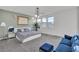 Bright bedroom featuring a large bed, modern decor, and a sitting area with natural light at 3206 Fountaintree Ave, Henderson, NV 89044