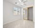 Bright bedroom with a ceiling fan, tile floors, window with blinds, and a closet with mirrored doors at 3431 Cottage Thistle Dr, Laughlin, NV 89029