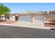 Beautiful home features a three-car garage, neutral color scheme, and rock landscaping for easy maintenance at 3431 Cottage Thistle Dr, Laughlin, NV 89029