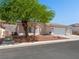 Lovely single-story home with a three-car garage, rock landscaping, and mature tree providing shade at 3431 Cottage Thistle Dr, Laughlin, NV 89029