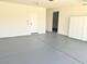 Garage featuring gray epoxy floors, white walls, a storage cabinet, and an entrance door to the house at 3431 Cottage Thistle Dr, Laughlin, NV 89029
